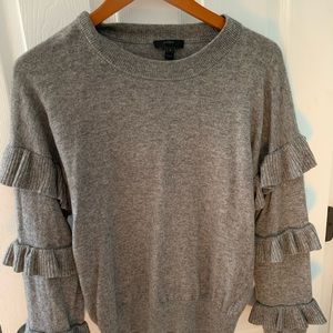 J Crew grey wool sweater with ruffle sleeves.